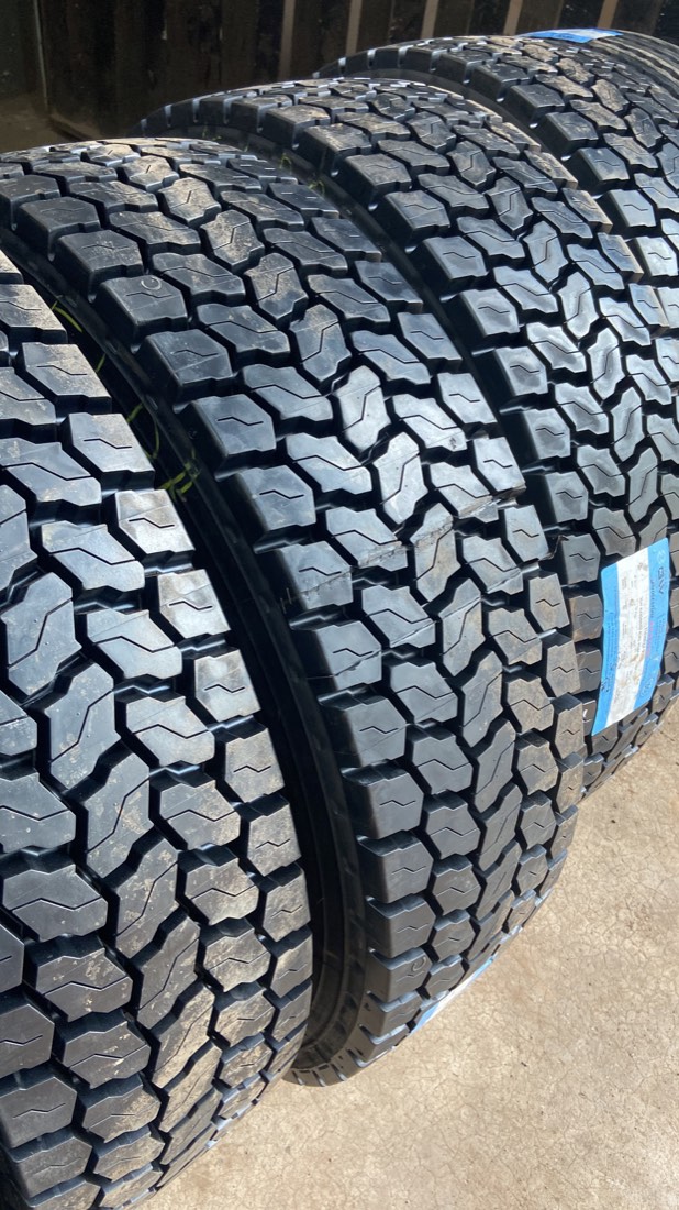 Pneus novos de carga empilhados, com a etiqueta Bridgestone visível